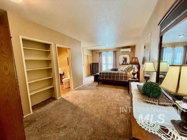 407 1st St, Asotin, WA 99402 - bedroom featuring a wall mounted air conditioner, carpet flooring, and ensuite bath