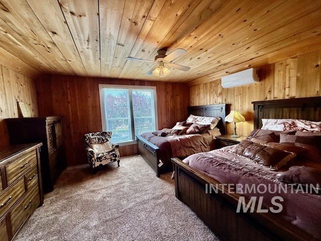 407 1st St, Asotin, WA 99402 - carpeted bedroom featuring an AC wall unit, wood ceiling, wooden walls, and a ceiling fan