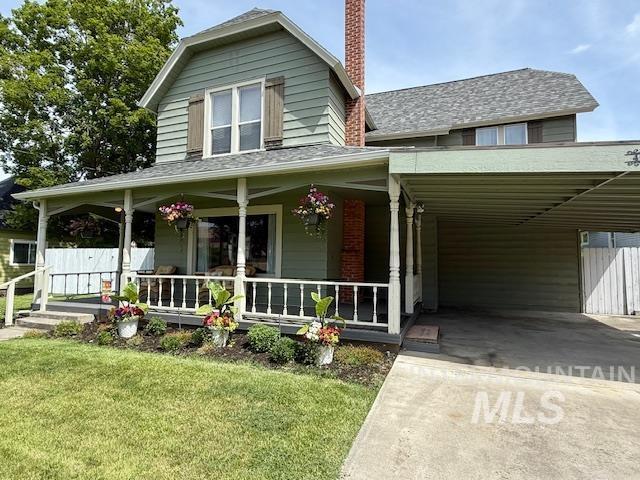 407 1st St, Asotin, WA 99402 - farmhouse-style home with a porch, a front yard, driveway, a chimney, and a carport