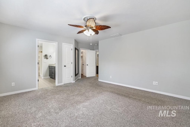 unfurnished bedroom with visible vents, a ceiling fan, baseboards, light colored carpet, and ensuite bathroom