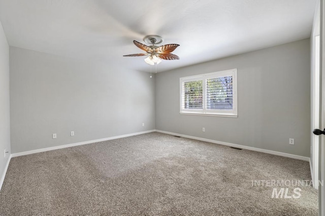 spare room featuring carpet floors, a ceiling fan, and baseboards