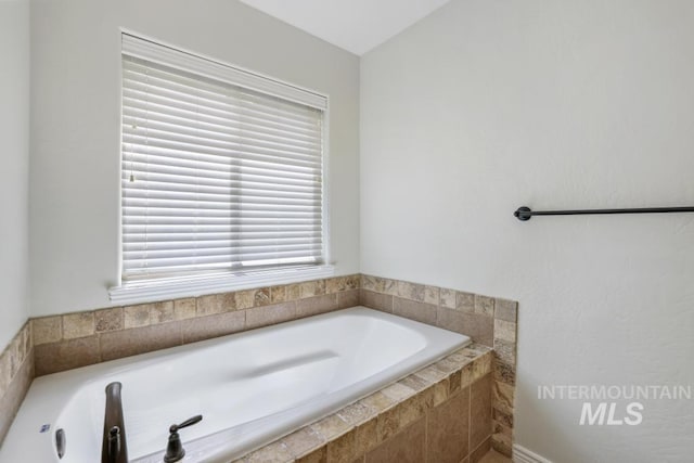 bathroom featuring a bath and plenty of natural light