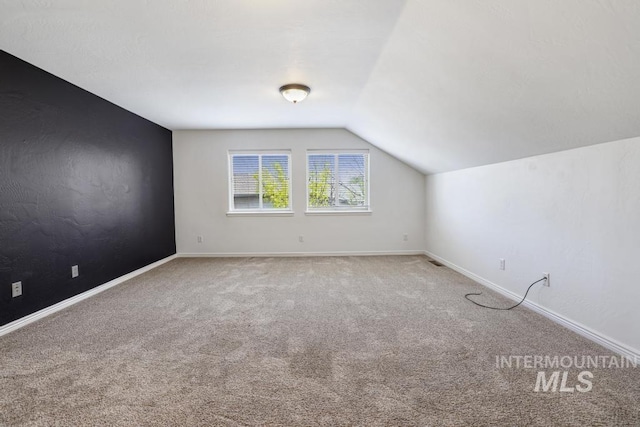 bonus room with carpet floors, vaulted ceiling, and baseboards