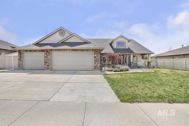 view of front of house featuring concrete driveway, stone siding, an attached garage, fence, and a front yard