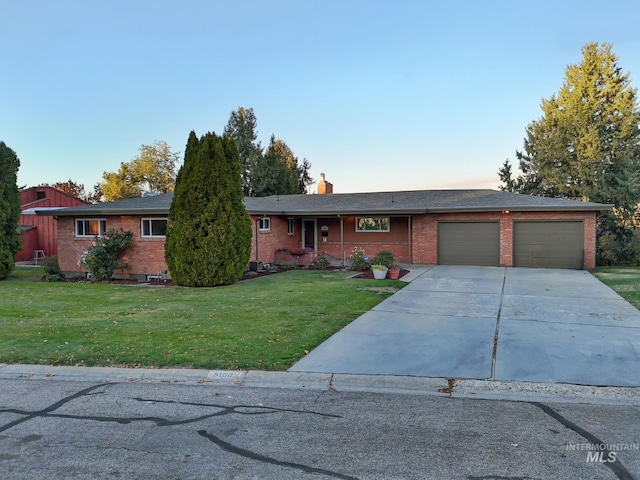 ranch-style house featuring a garage and a front yard