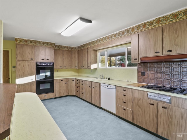 kitchen featuring decorative backsplash, black appliances, and sink