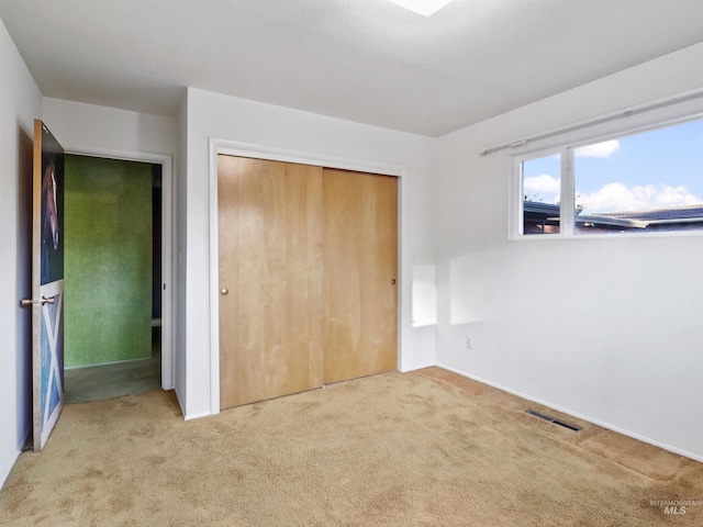 unfurnished bedroom with carpet floors and a closet