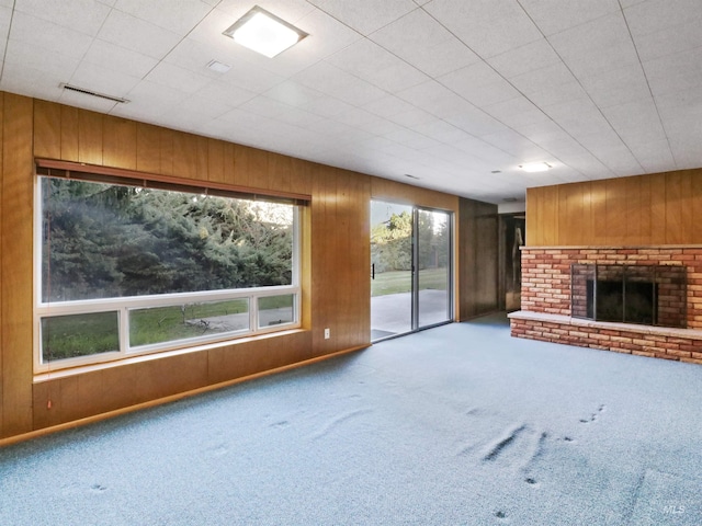 unfurnished living room with wooden walls and carpet flooring