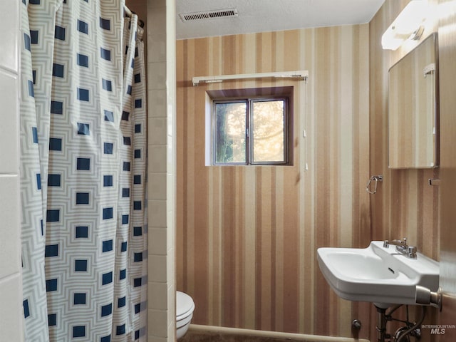 bathroom featuring toilet, a shower with curtain, sink, and a textured ceiling