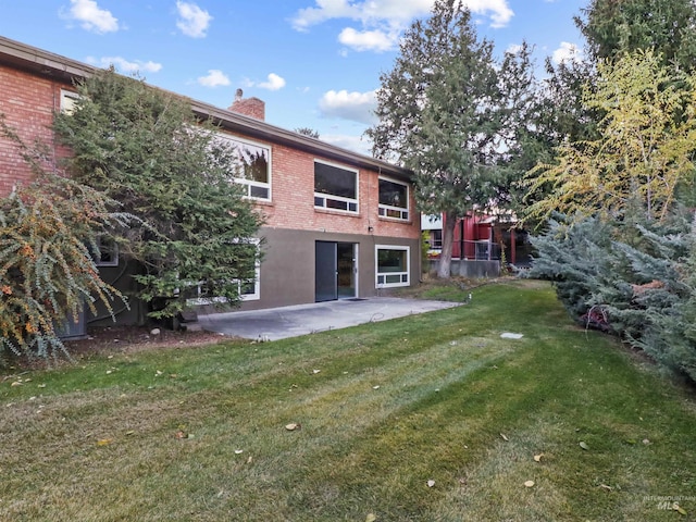 rear view of house featuring a patio and a yard