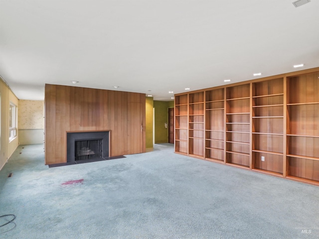 unfurnished living room featuring light carpet and a large fireplace