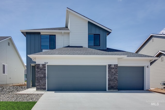 view of front of property with board and batten siding, stone siding, and concrete driveway