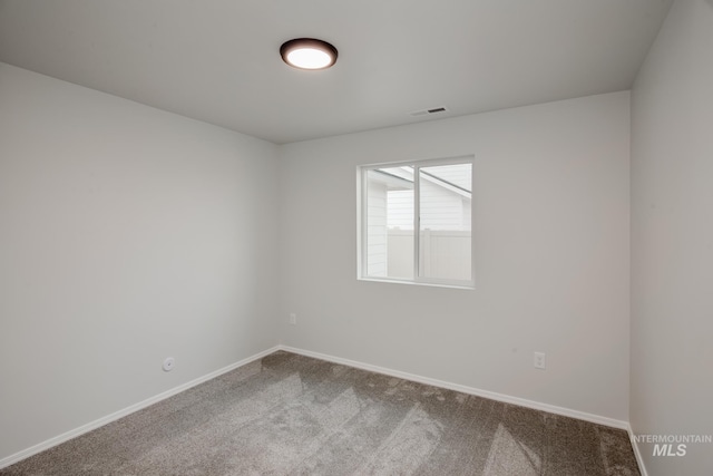 carpeted empty room featuring visible vents and baseboards