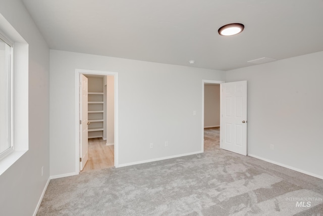 spare room featuring carpet floors and baseboards