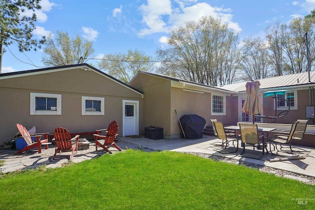 360 N 700 W, Paul, ID 83347 - rear view of property with a patio, a fire pit, a lawn, and stucco siding