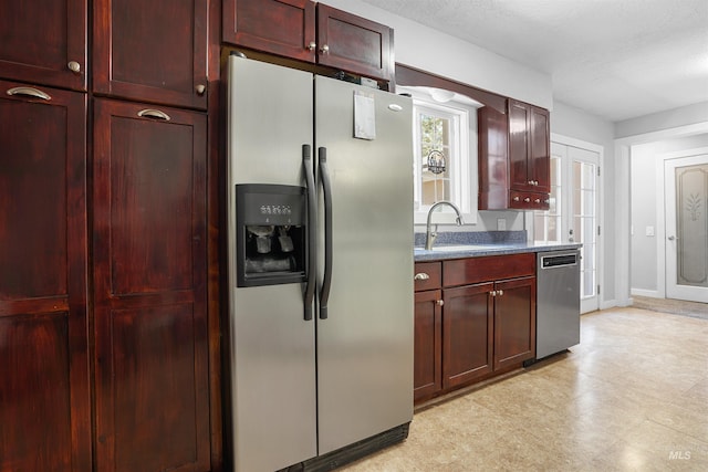 360 N 700 W, Paul, ID 83347 - kitchen featuring appliances with stainless steel finishes, dark brown cabinets, a sink, and baseboards