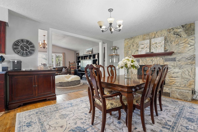 360 N 700 W, Paul, ID 83347 - dining area with a chandelier, a textured ceiling, light wood-style flooring, and lofted ceiling