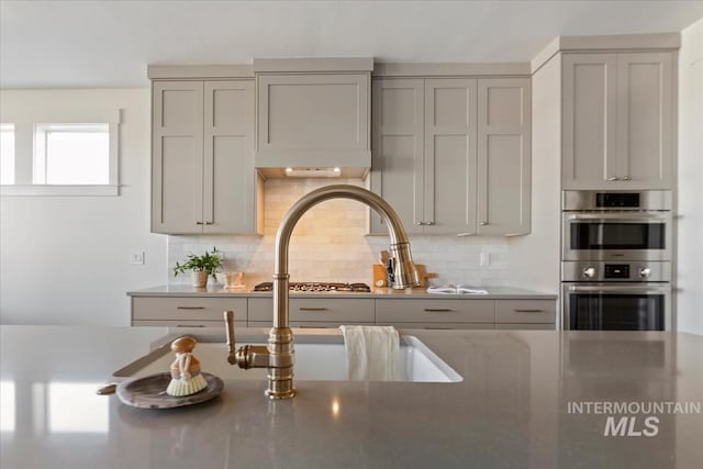 4265 W Thornapple Dr, Meridian, ID 83646 - kitchen with gray cabinets, double oven, and decorative backsplash