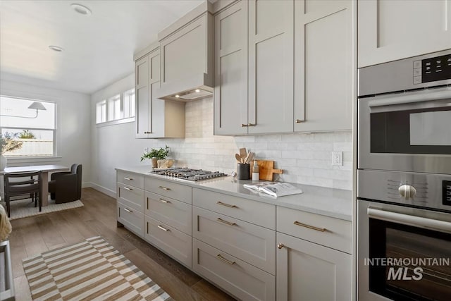 4265 W Thornapple Dr, Meridian, ID 83646 - kitchen with light countertops, tasteful backsplash, stainless steel appliances, wood finished floors, and baseboards