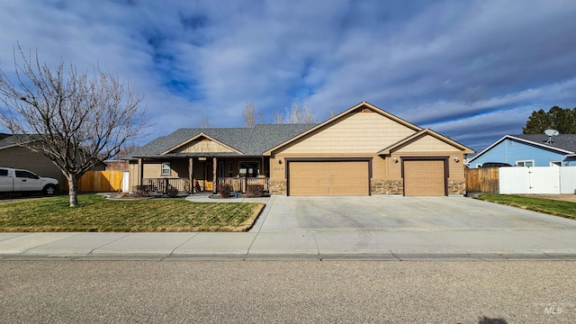 view of front of house with a garage, a front lawn, and covered porch