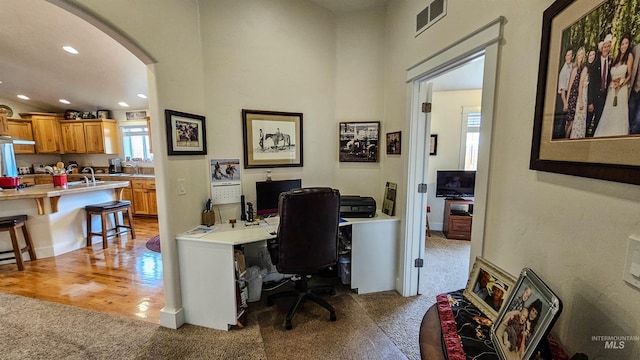 carpeted home office featuring sink