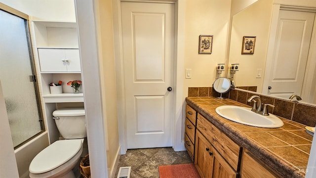 full bathroom with toilet, vanity, and shower / bath combination with glass door