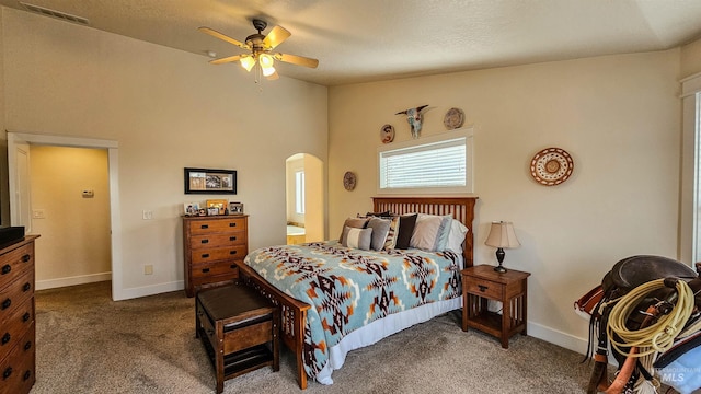 bedroom with ceiling fan, vaulted ceiling, and dark colored carpet