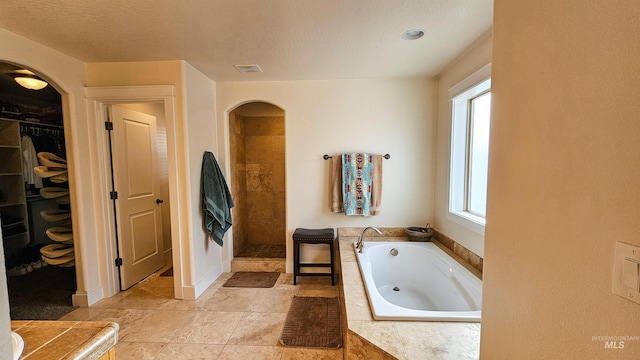 bathroom with a wealth of natural light, tile patterned flooring, and separate shower and tub