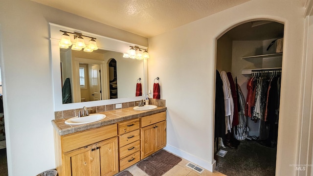 bathroom featuring a textured ceiling, vanity, and tile patterned flooring