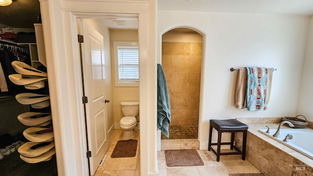 bathroom featuring tile patterned flooring, toilet, and shower with separate bathtub