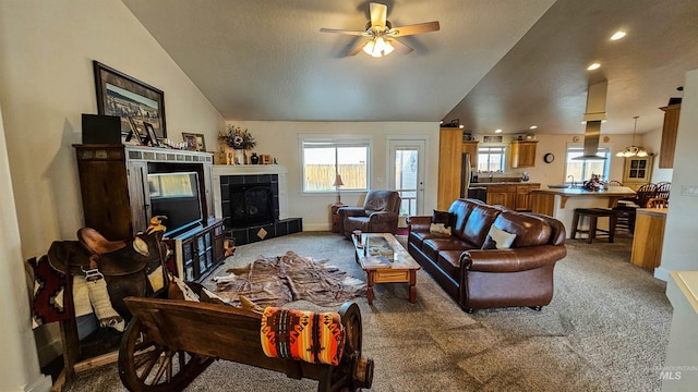 carpeted living room with vaulted ceiling and ceiling fan