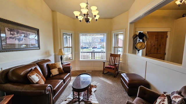 carpeted living room with a chandelier