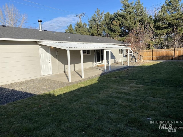 back of property featuring a yard, a patio area, and fence