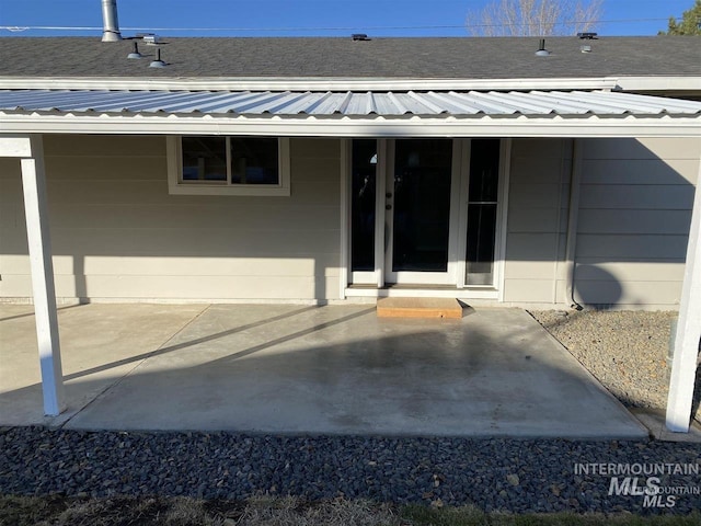 property entrance with a patio area and metal roof