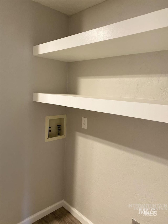 clothes washing area with laundry area, baseboards, washer hookup, and dark wood finished floors