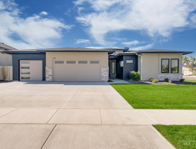 prairie-style house featuring a front lawn and a garage