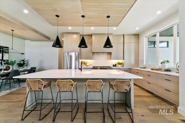 kitchen featuring decorative light fixtures, high end fridge, and a spacious island