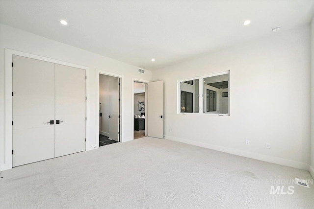 unfurnished bedroom with carpet flooring and a closet