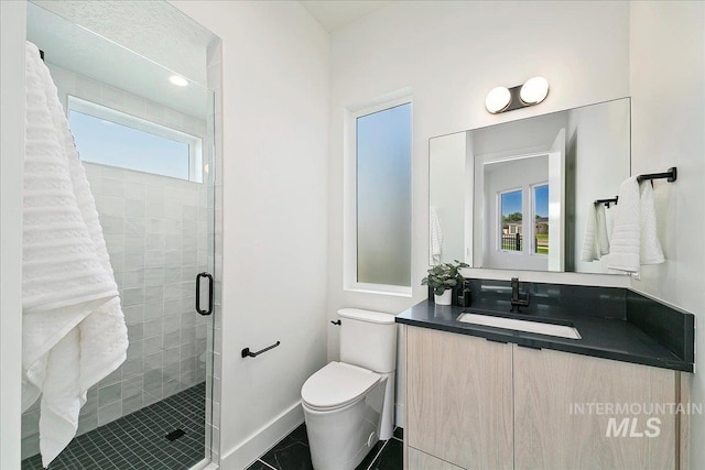 bathroom with tile patterned flooring, vanity, a shower with shower door, and toilet