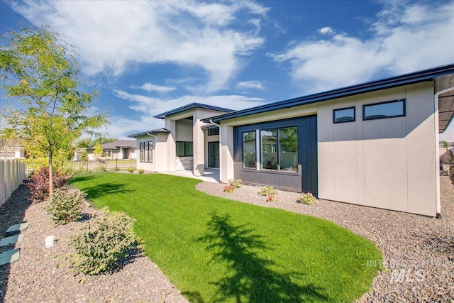 rear view of house featuring a lawn