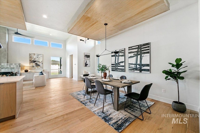 dining room with a towering ceiling and light hardwood / wood-style flooring