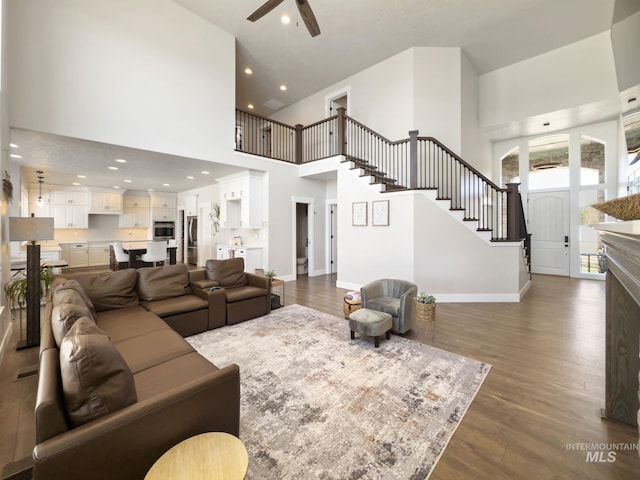 7063 S Pear Blossom, Meridian, ID 83642 - living area featuring baseboards, a ceiling fan, dark wood finished floors, a towering ceiling, and stairs
