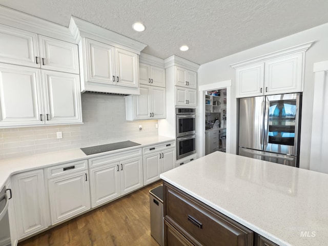 7063 S Pear Blossom, Meridian, ID 83642 - kitchen featuring white cabinetry, recessed lighting, appliances with stainless steel finishes, dark wood-style flooring, and backsplash