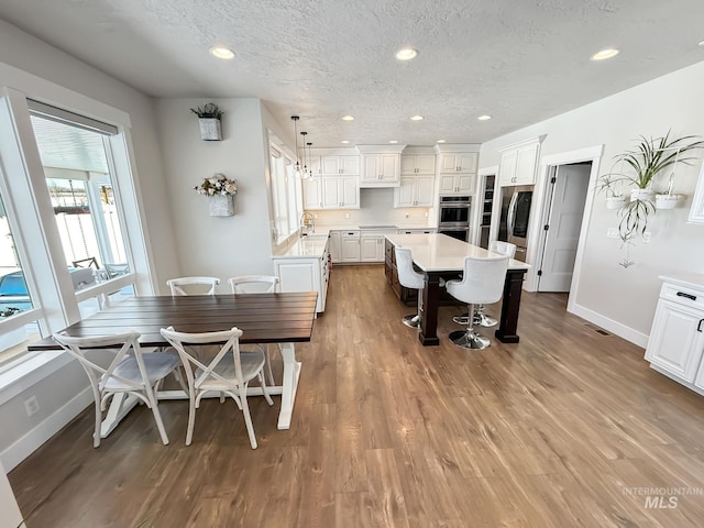 7063 S Pear Blossom, Meridian, ID 83642 - dining space with recessed lighting, baseboards, a textured ceiling, and wood finished floors