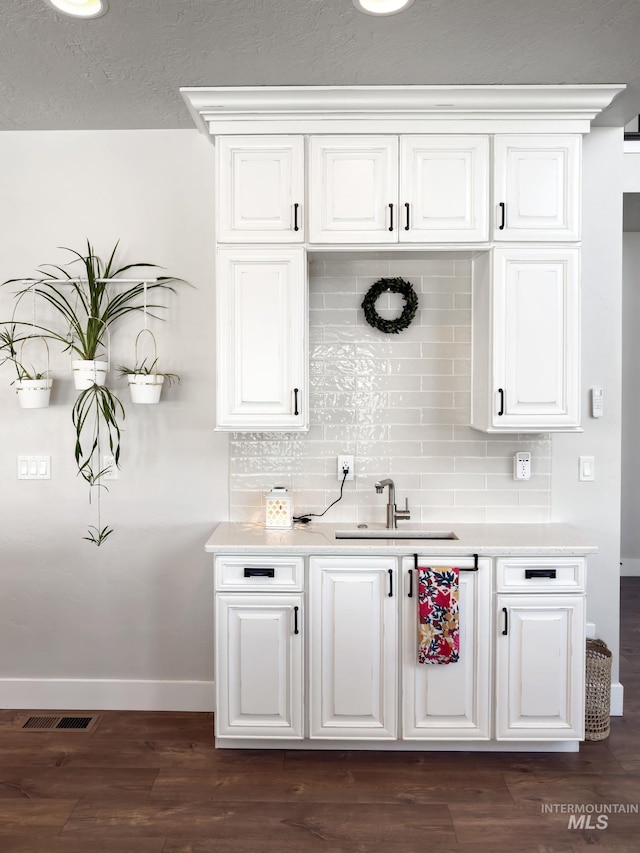 7063 S Pear Blossom, Meridian, ID 83642 - kitchen with tasteful backsplash, baseboards, white cabinets, a sink, and light countertops