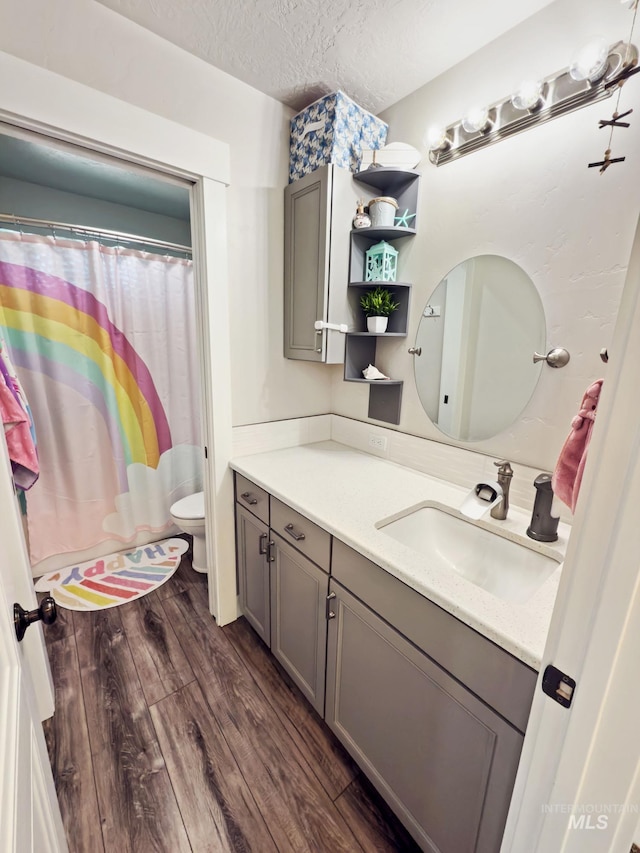 7063 S Pear Blossom, Meridian, ID 83642 - full bath featuring a shower with curtain, toilet, a textured ceiling, vanity, and wood finished floors