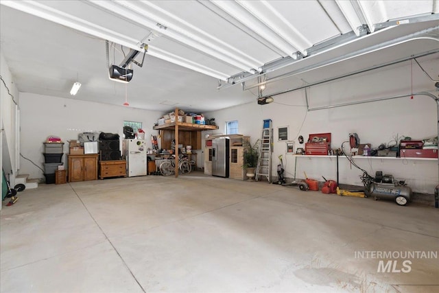 42 Hiatt Cir, Idaho City, ID 83631 - garage with a garage door opener, freestanding refrigerator, and stainless steel refrigerator with ice dispenser