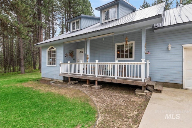 42 Hiatt Cir, Idaho City, ID 83631 - view of front of home featuring a porch, metal roof, a front lawn, and a garage