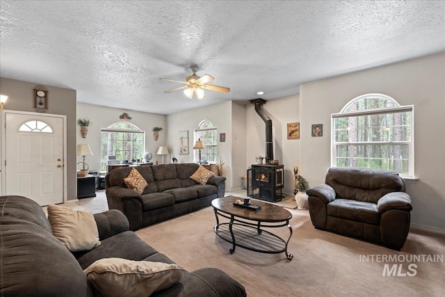 42 Hiatt Cir, Idaho City, ID 83631 - carpeted living room featuring a wood stove, a ceiling fan, and a textured ceiling