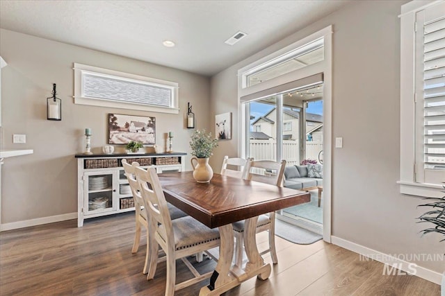 dining area featuring light wood-style floors, baseboards, visible vents, and a healthy amount of sunlight